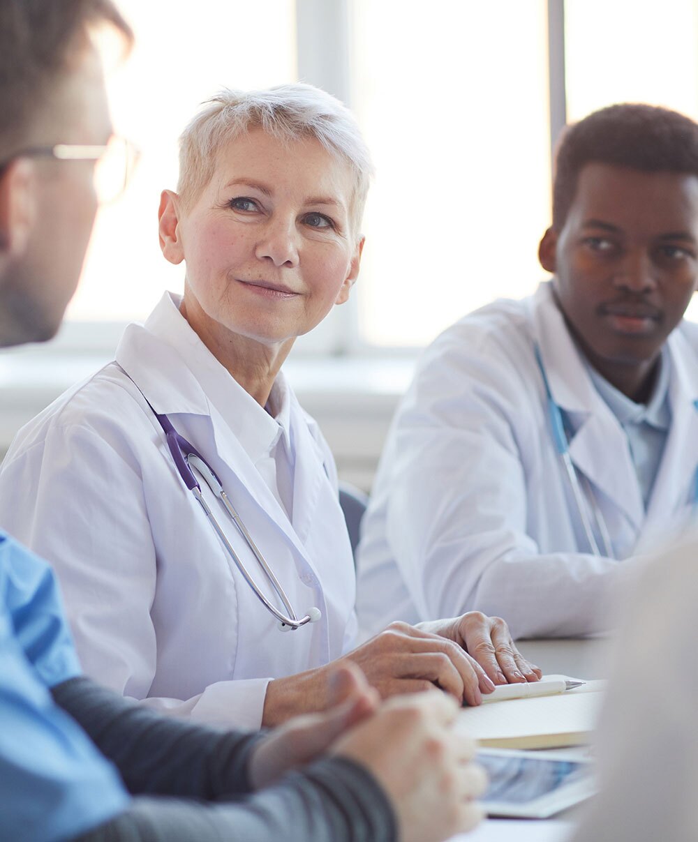 Doctors in a meeting sitting at a table.