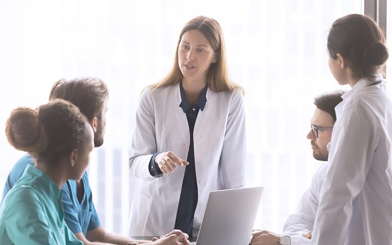 Healthcare professionals meeting around conference table.